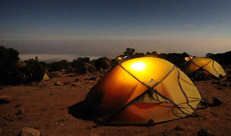 Two tents overlooking a cliff at dusk.